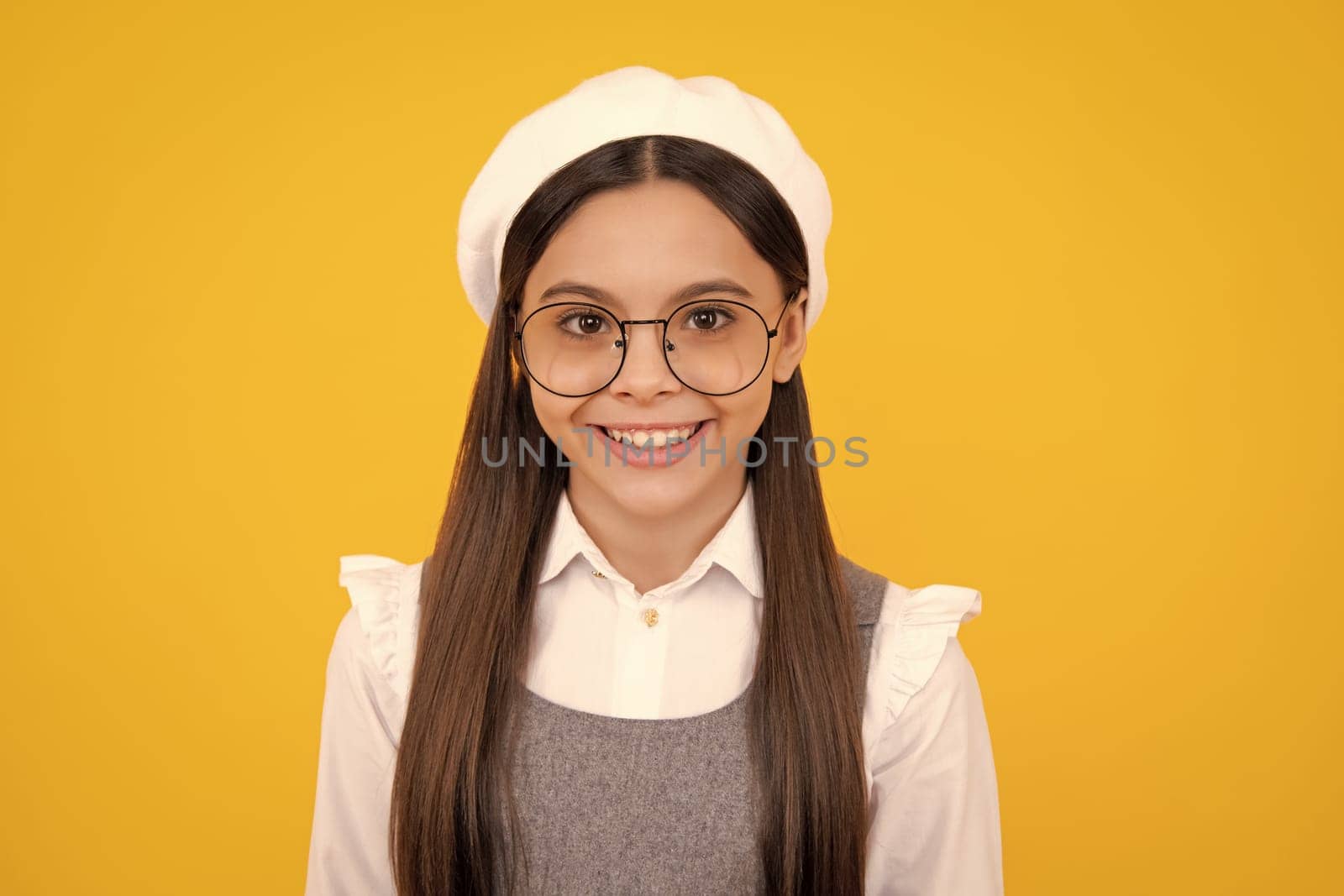 Portrait of pretty teen girl. Latin or hispanic teenager child isolated on yellow background. Happy face, positive and smiling emotions of teenager girl