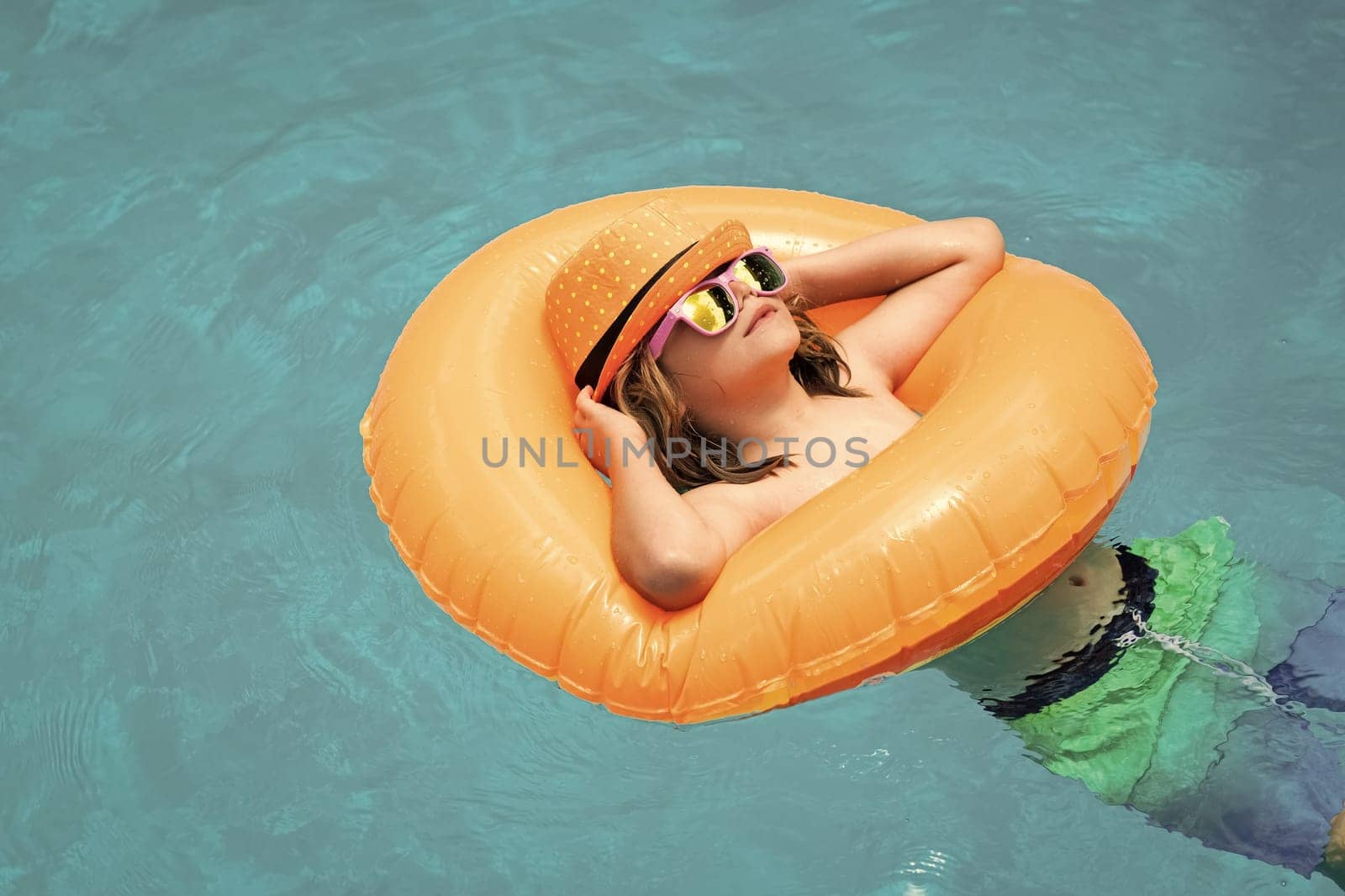 Happy child enjoying summer vacation outdoors in the water in the swimming pool