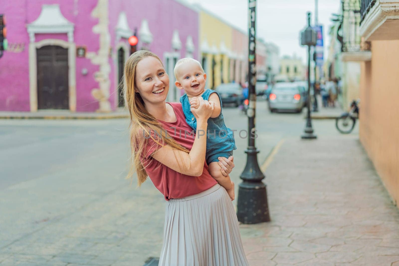 Mother and baby son tourists explore the vibrant streets of Valladolid, Mexico, immersing herself in the rich culture and colorful architecture of this charming colonial town by galitskaya