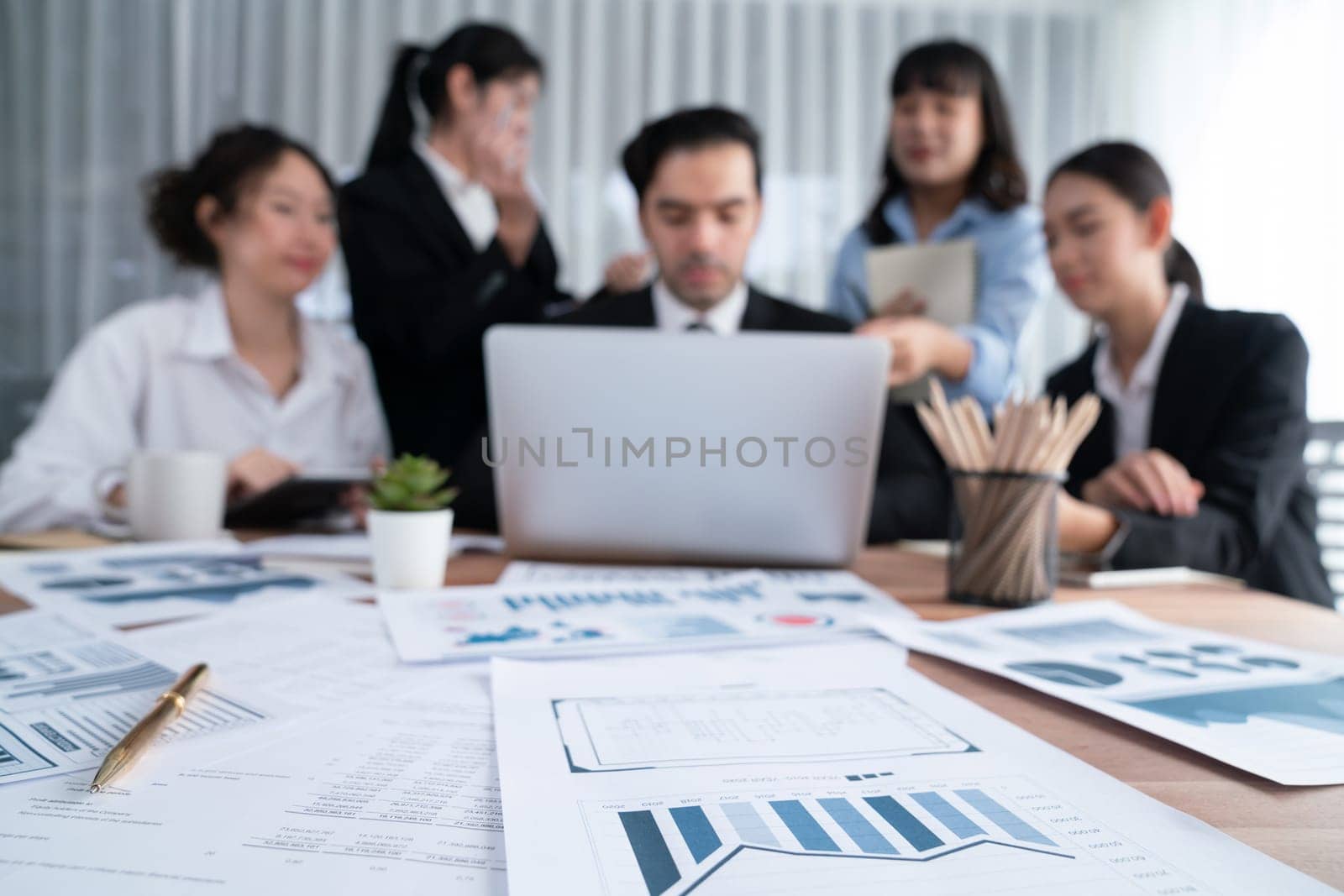 Focus financial data dashboard paper by business intelligence display graph, chart and statistic report on office table with blurred business people working in background. Habiliment