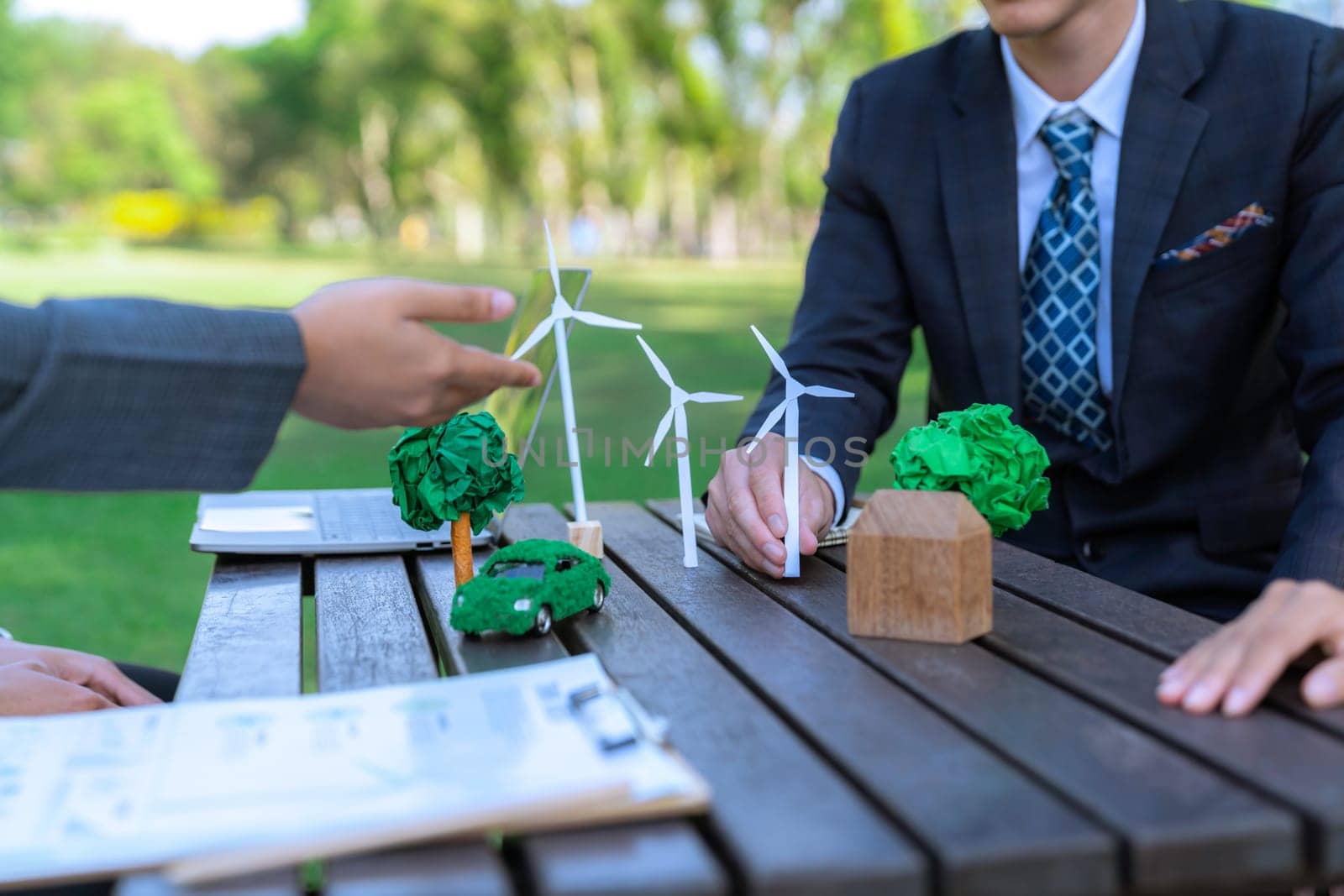 Group of asian business people presenting environmentally friendly development plan and sustainable technology project for greener future, establishing outdoor eco business office at natural park.Gyre