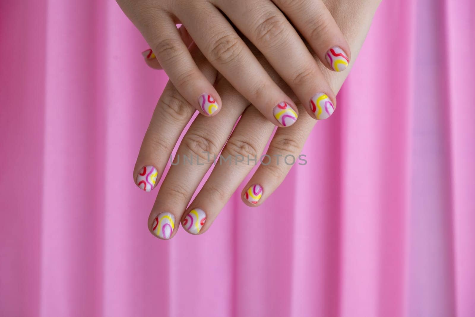 Pastel softness colorful manicured nails on pink background. Woman showing her new summer manicure in colors of pastel palette. Simplicity decor fresh spring vibes earth-colored neutral tones by anna_stasiia