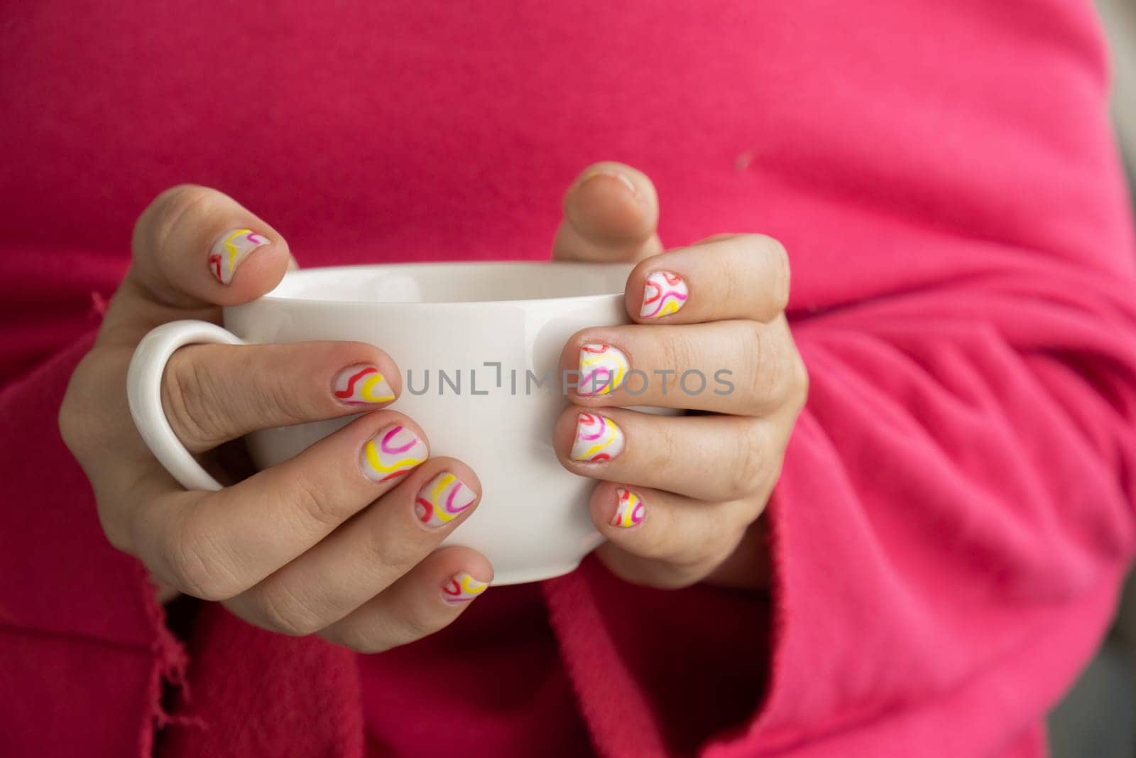 Stylish colorful summer female nails holding white cup of coffee or tea. Modern trendy stylish Beautiful manicure. Cute pastel nail minimalistic design concept of beauty treatment. Gel nails. Skin care by anna_stasiia