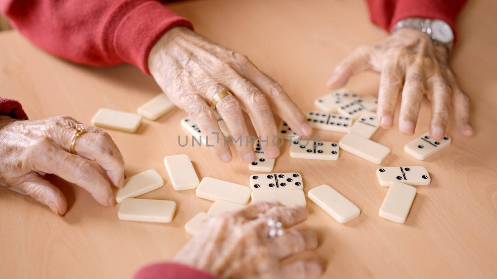 Senior people sorting the domino tiles in a geriatric by ivanmoreno