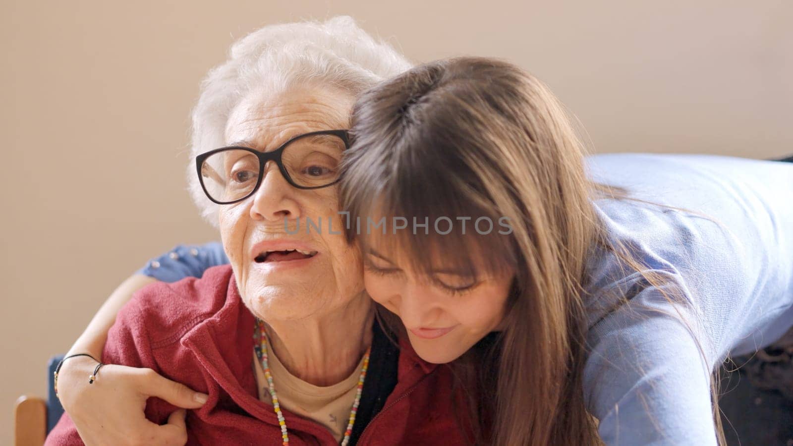 Cute granddaughter embracing her grandmother in a geriatric