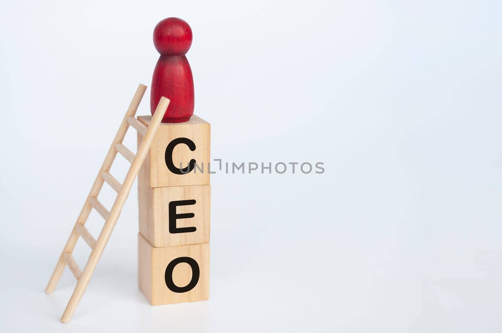 Red doll figure on top of wooden cubes with CEO text. Leadership and success concept.