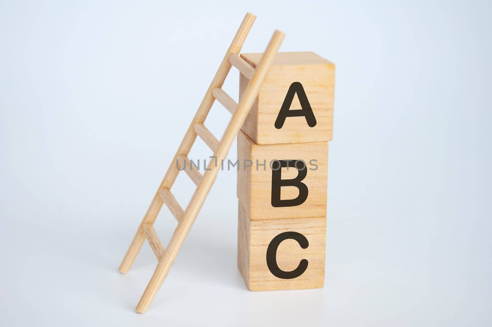ABC text on wooden cubes with ladder on white background. Learning concept.