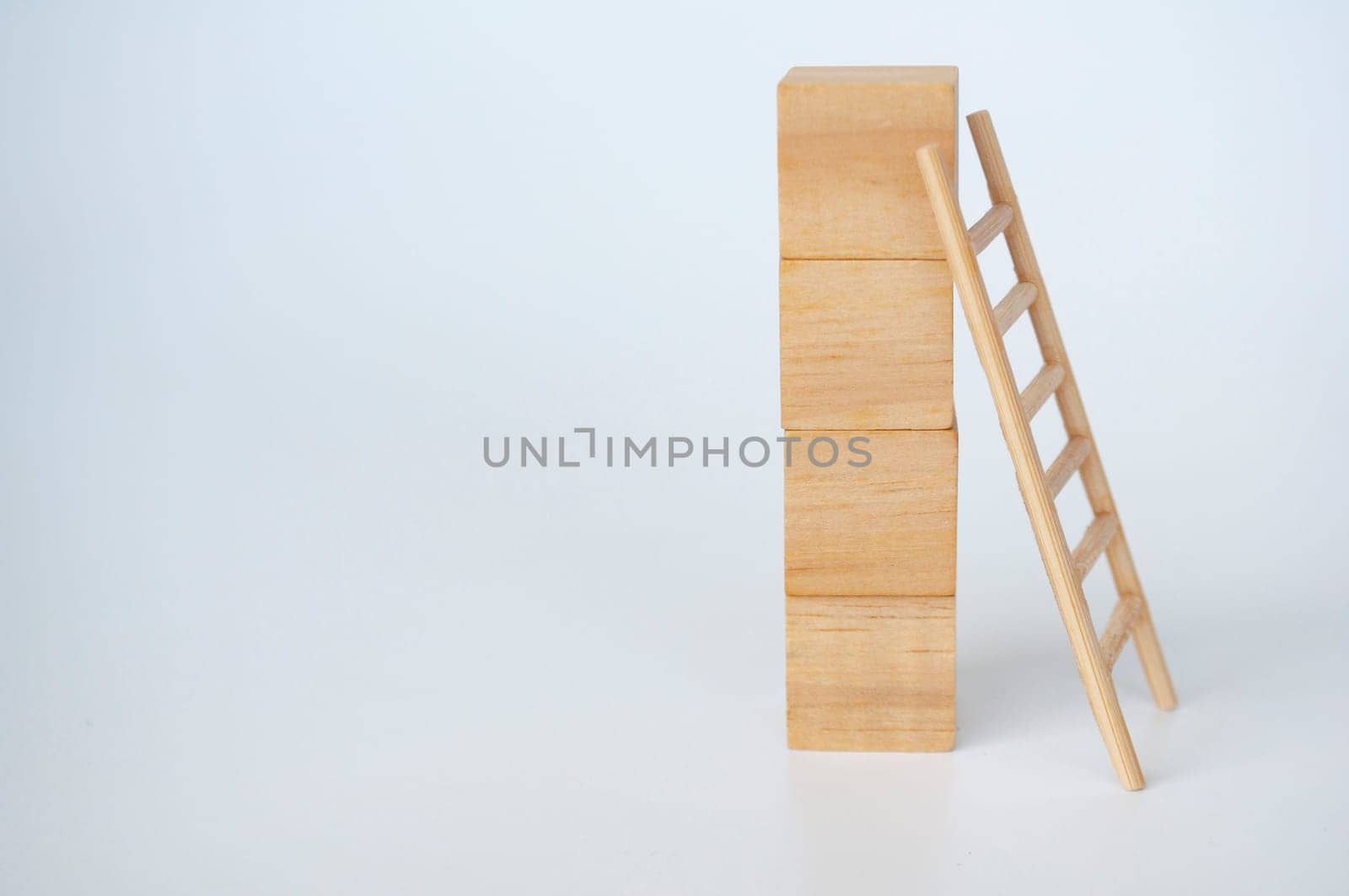 Wooden cubes with ladder on white background with customizable space for text.