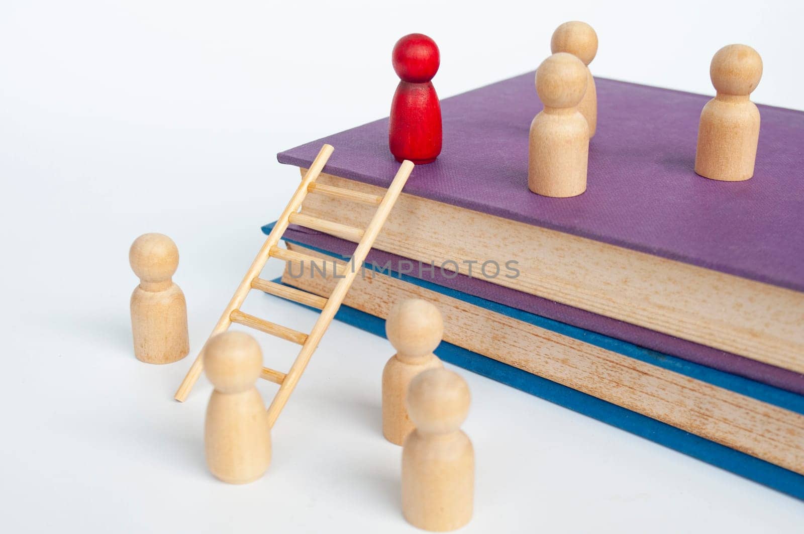 Ladder of success concept with books and doll figure climbing books with ladder. Success concept.