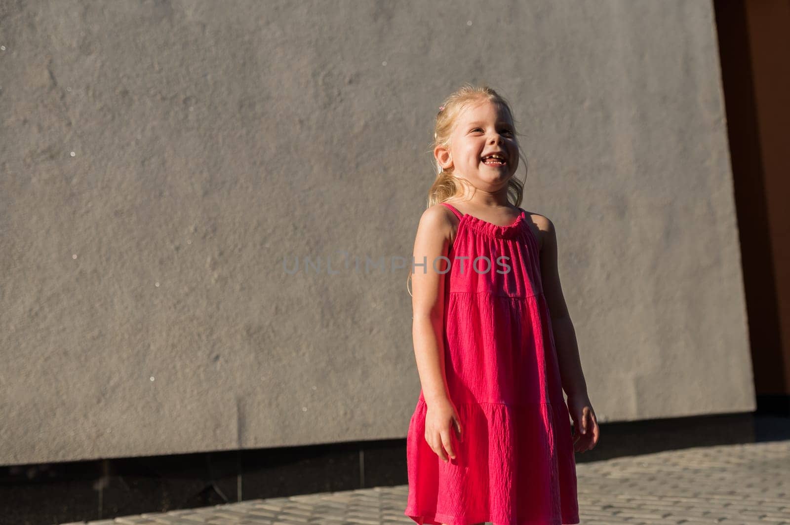 Child girl with hearing aids and cochlear implants having fun outdoor speak and playing. Copy space and empty place for advertising by Satura86
