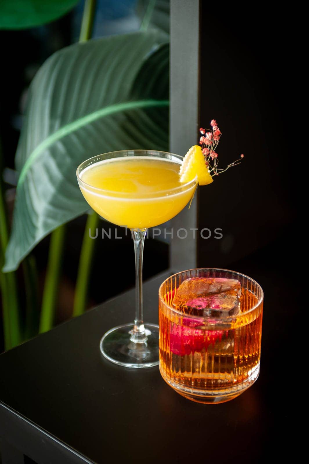Two refreshing summer cocktails with lemon, mint, cranberry on a table. High quality photo