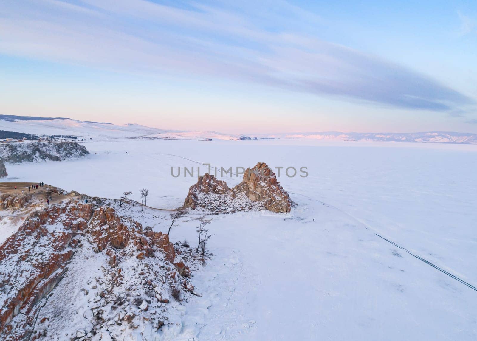 Aerial shot of a Shamanka rock on Olkhon island at sunset. Winter landscape. Popular touristic destination. Natural landmark. Panoramic view by Busker