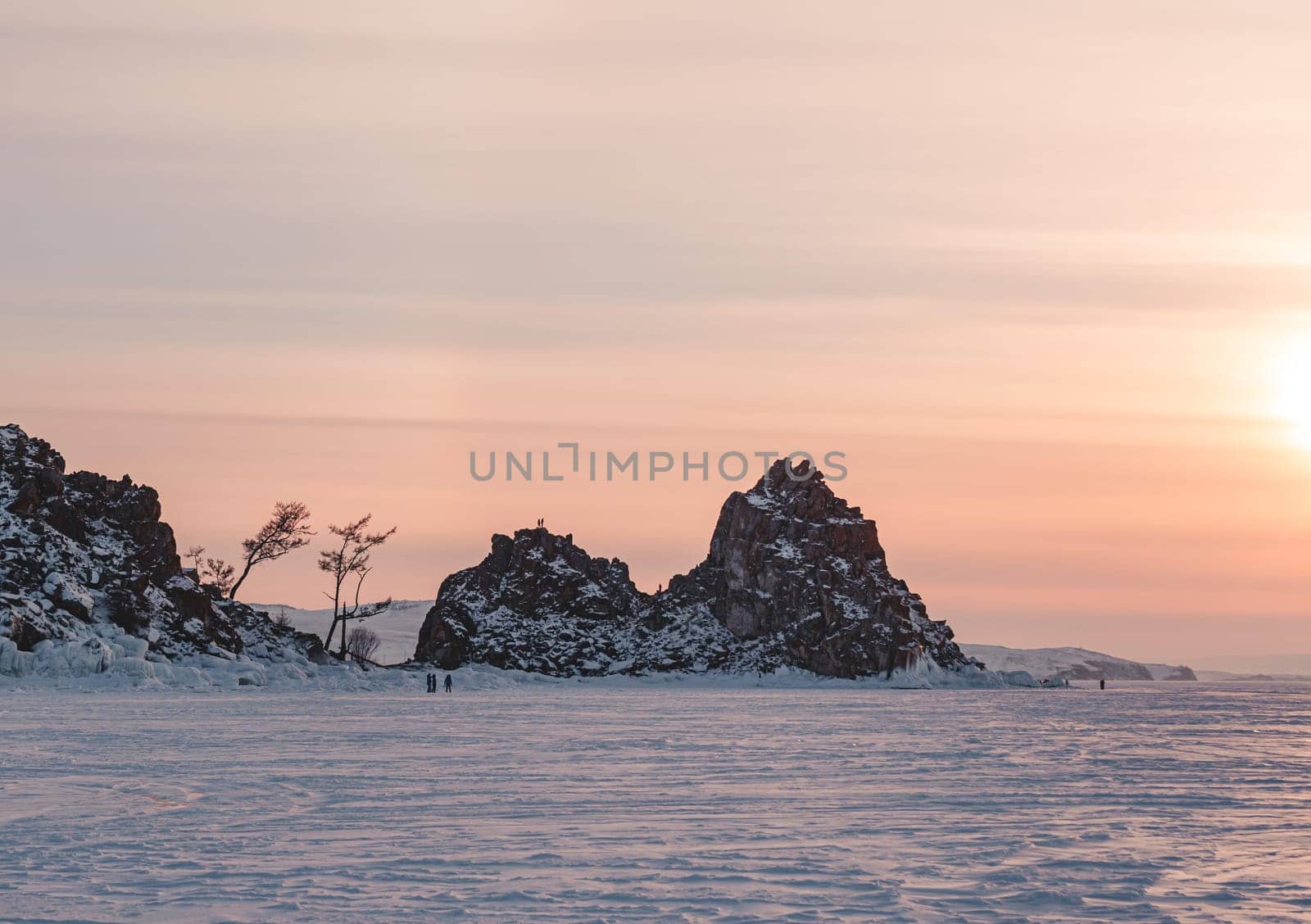 Shamanka rock on Olkhon island on the sunset. Winter landscape of lake Baikal. Famous tourist spot on Baikal