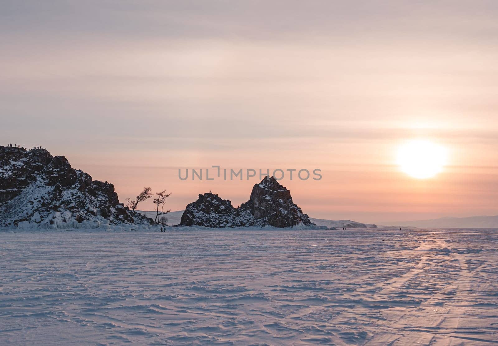 Shamanka rock on Olkhon island on the sunset. Winter landscape of lake Baikal. Famous tourist spot on Baikal