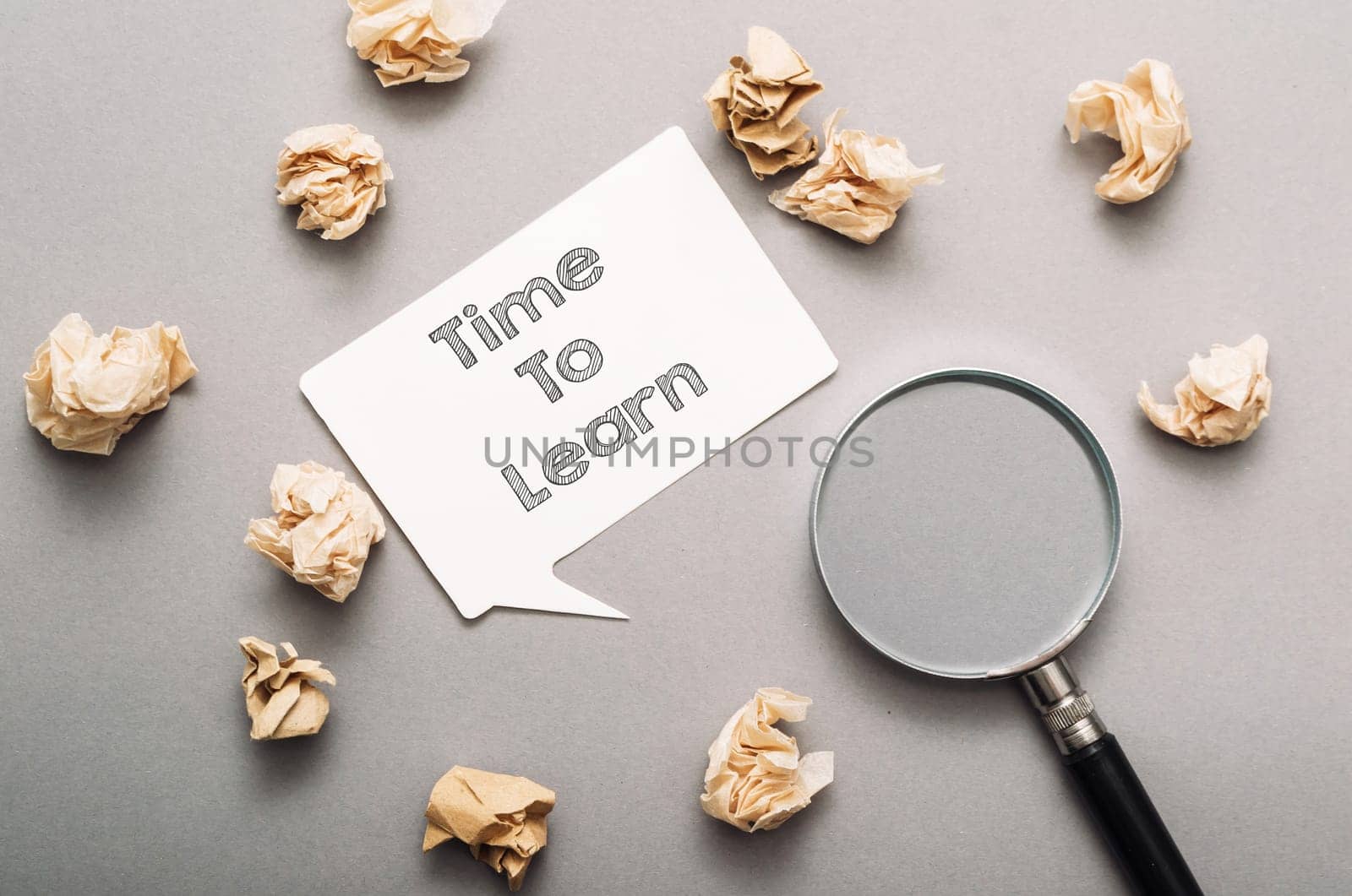 A white sign with the words Time to Learn written on it is surrounded by shredded paper. The shredded paper is scattered around the sign, creating a sense of chaos and disorganization