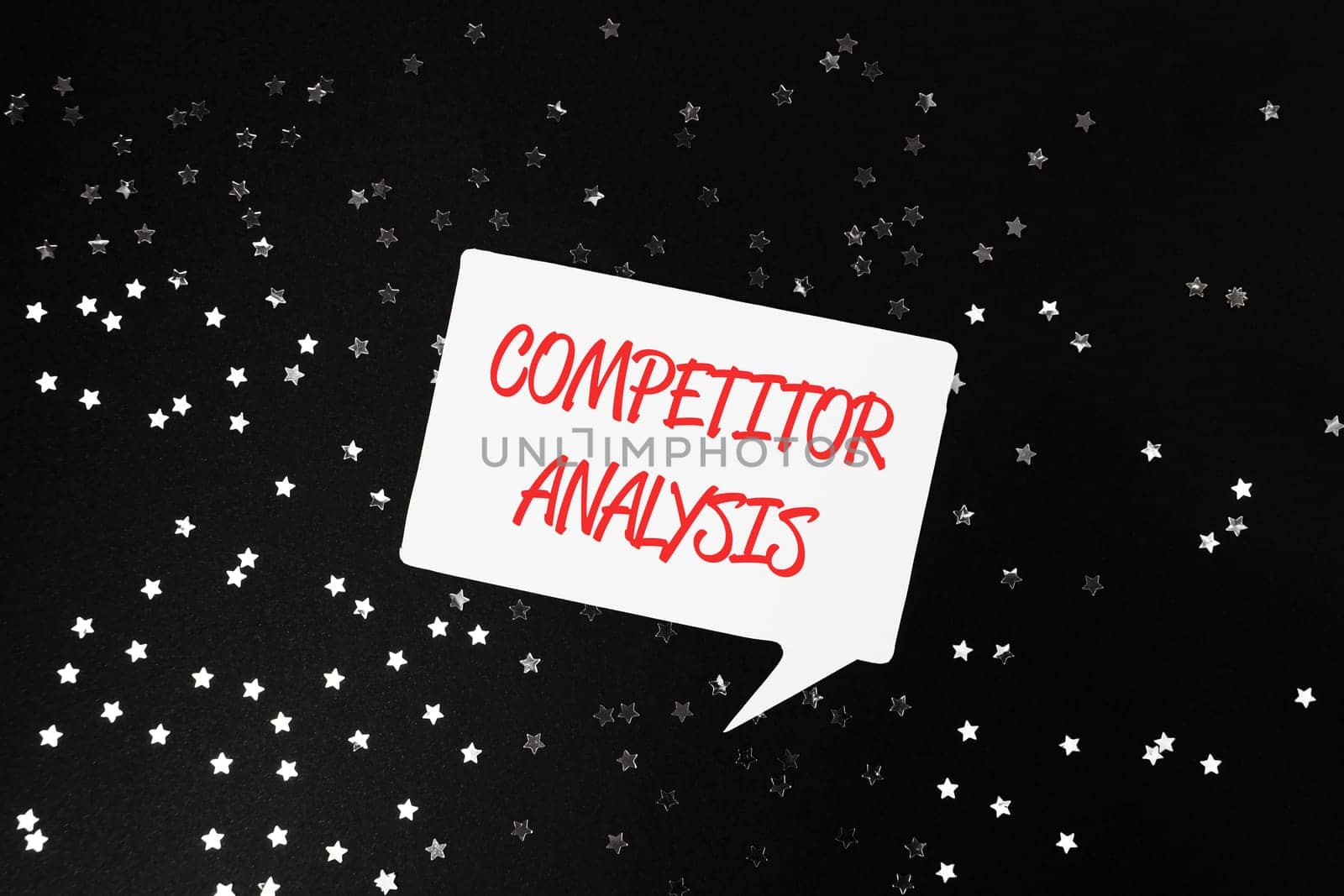 A white sign with red letters that says Competitor Analysis is surrounded by a star pattern