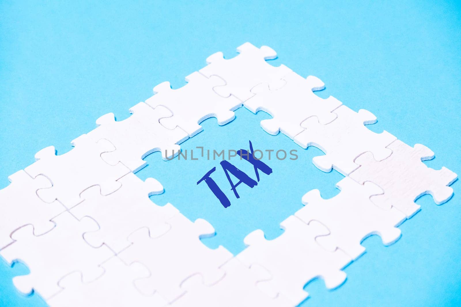 A puzzle piece with the word tax written in blue, symbolizing the complexity and challenge of tax-related matters.