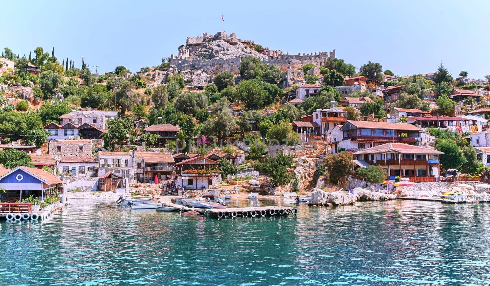 Scenic Turkish Village on Hill Overlooking Boats in Crystal Blue Sea by Hil