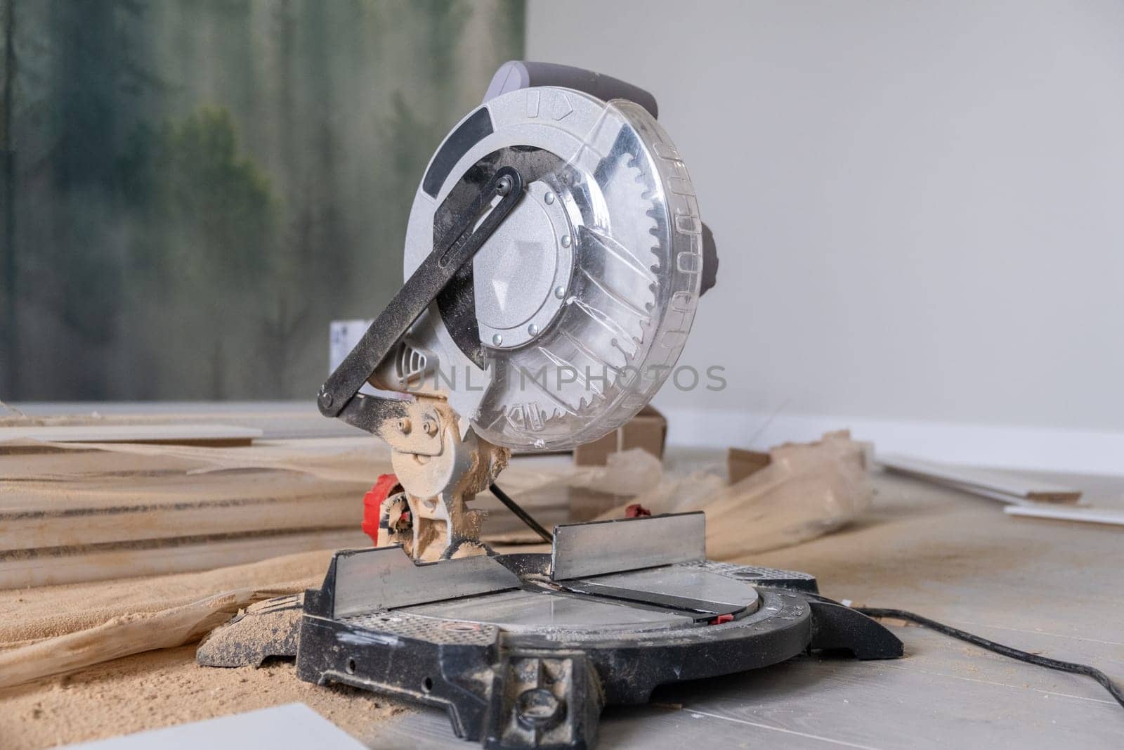 The miter saw or a multi material construction saw on the floor of the apartment by AnatoliiFoto