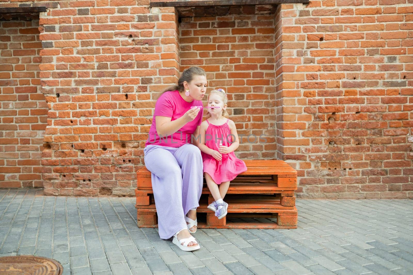 Mother holds and have fun her child with hearing aids and cochlear implants summer outdoor . Deaf and health concept. Diversity and inclusion. Copy space by Satura86