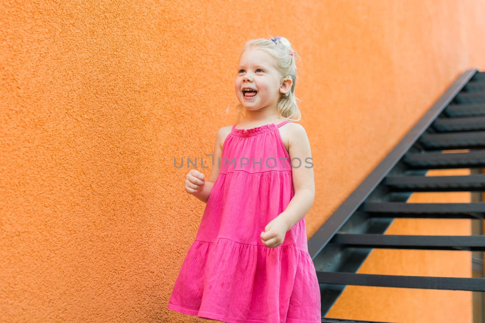 Child girl with hearing aids and cochlear implants having fun outdoor speak and playing. Copy space and empty place for advertising.