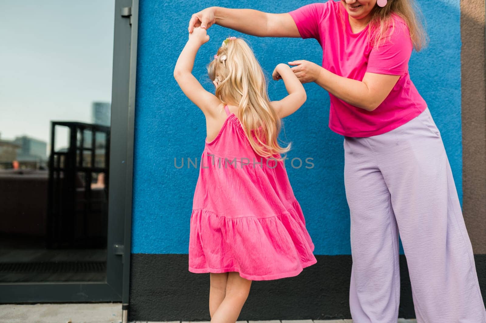 Mother holds and have fun her child with hearing aids and cochlear implants summer outdoor . Deaf and health concept. Diversity and inclusion. Copy space.