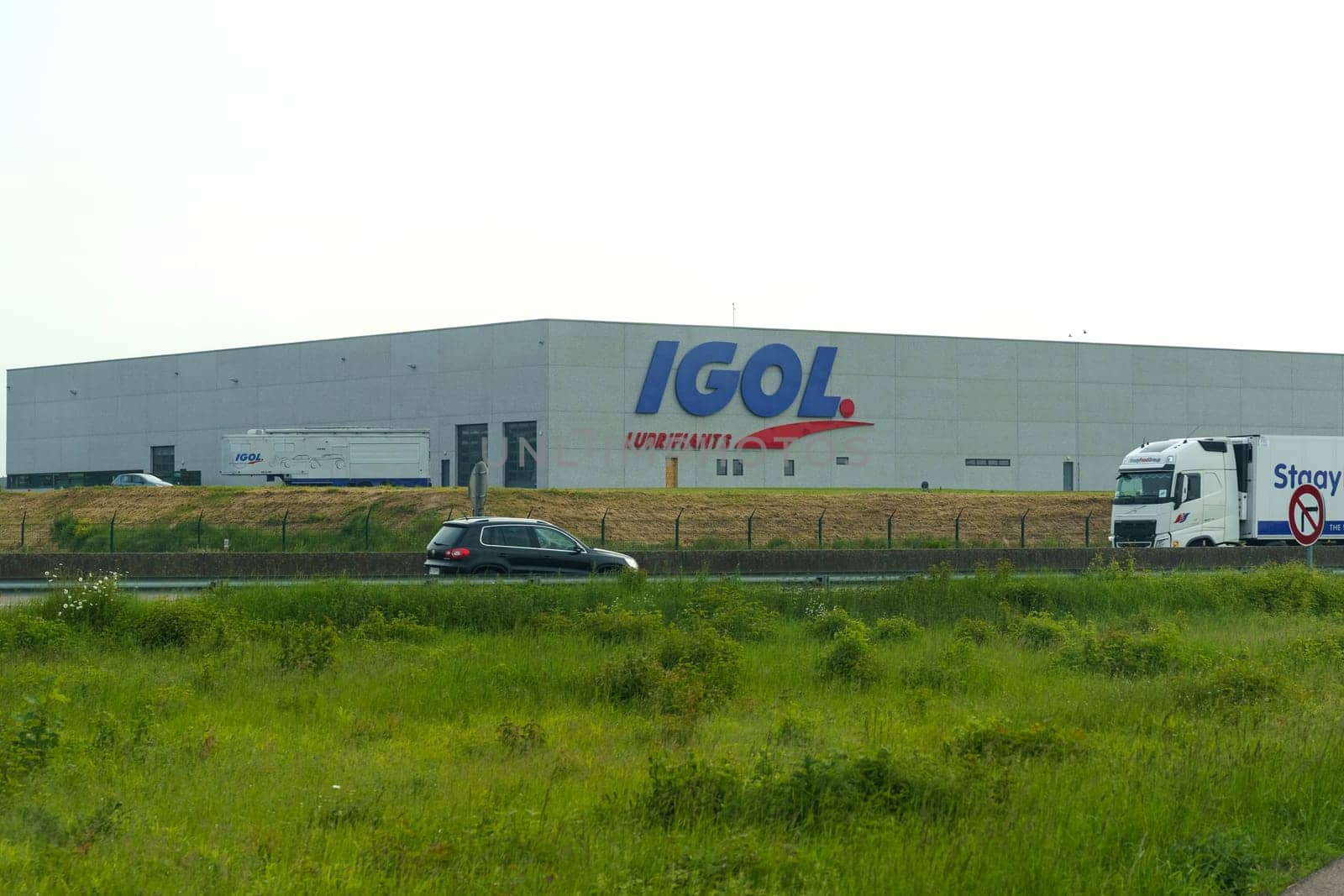 Bauvin, France - May 22, 2023:Exterior of IGOL Lubricants warehouse with logo, alongside a no parking sign and grassy embankment during the day.