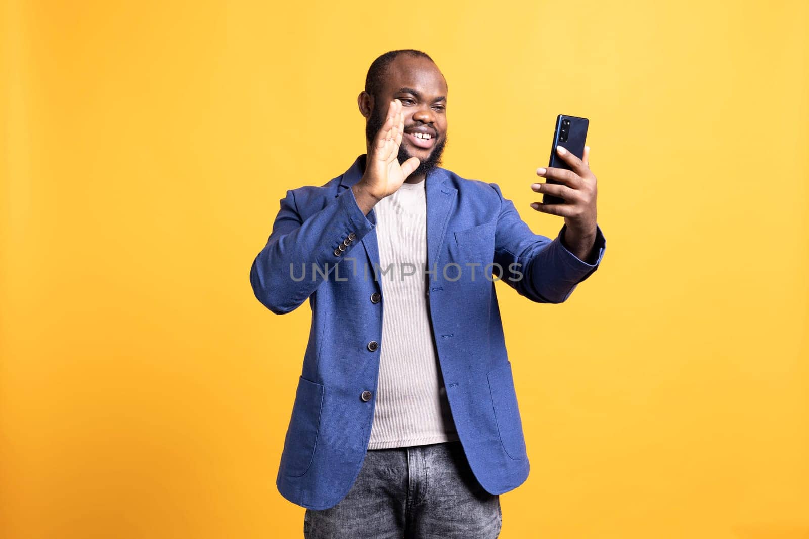 Happy person waving hand, saluting mate during video call, studio background by DCStudio