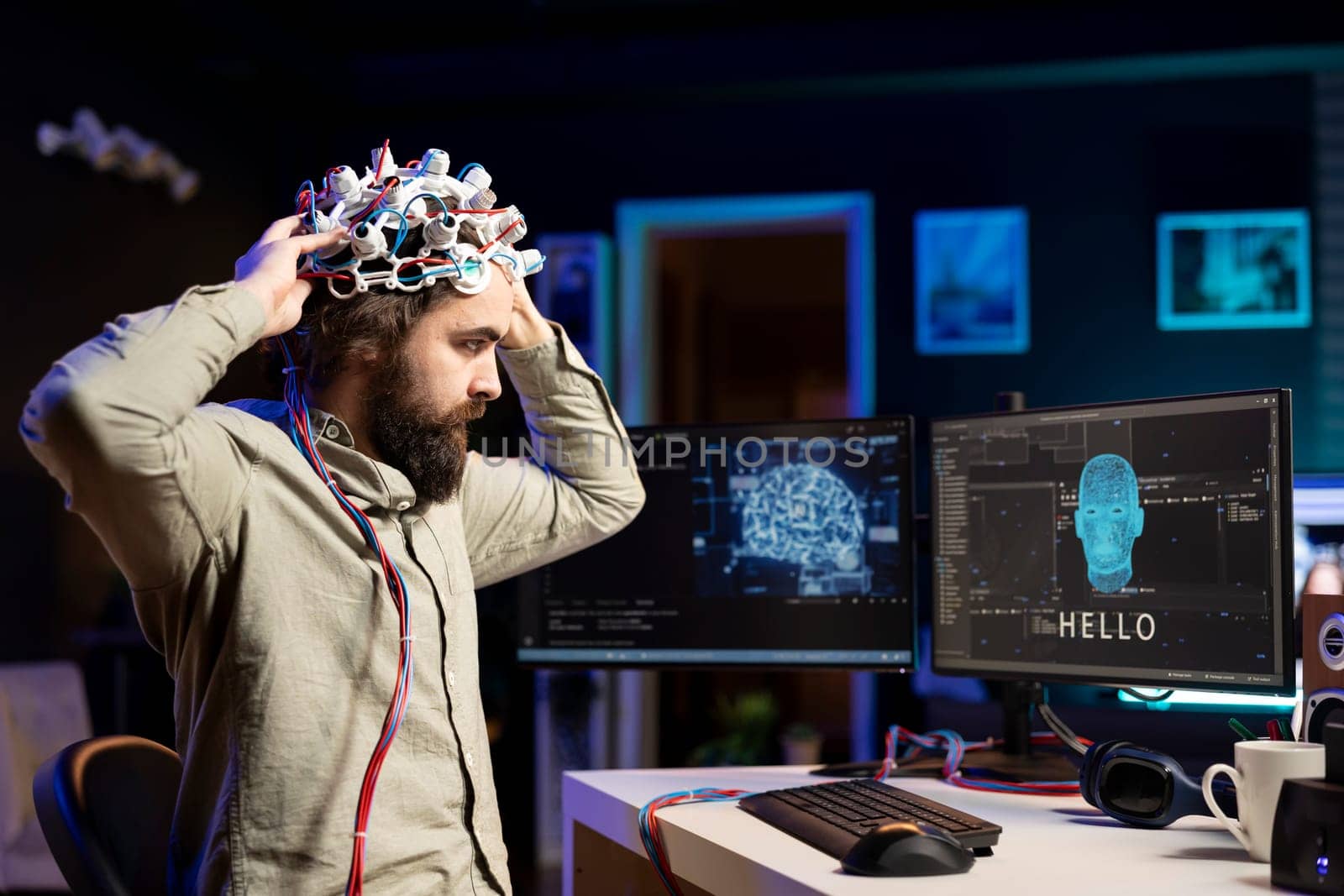 IT specialist putting EEG headset on to communicate with artificial intelligence on computer in binary code. Software engineer sending brainwave signals to sentient AI on PC using high tech device