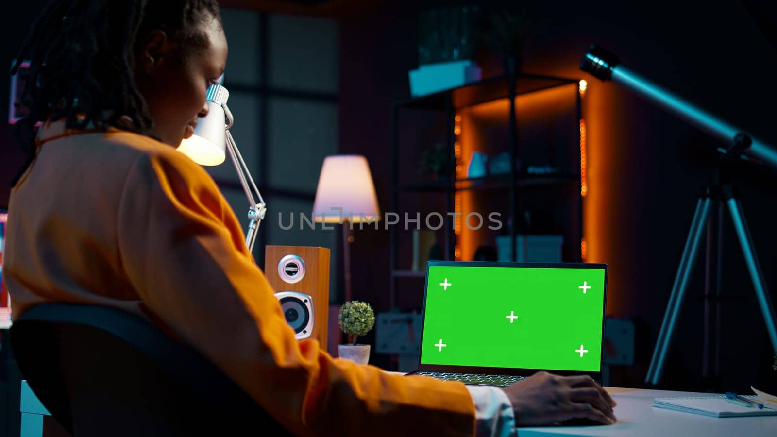 University student checks greenscreen display on laptop at home, improving her education and using isolated chromakey layout on wireless device. Girl looks at mockup screen. Camera B.