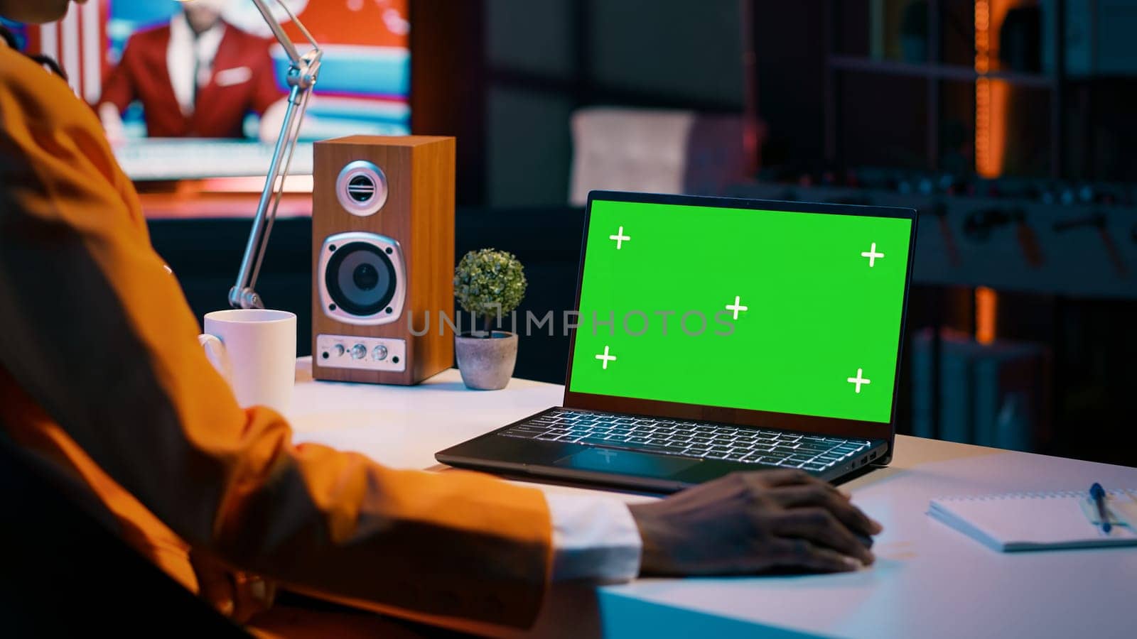 Young woman using laptop with isolated greenscreen display at her home office, resolving homework tasks for university courses. Student looking at blank copyspace chromakey on pc. Camera A.