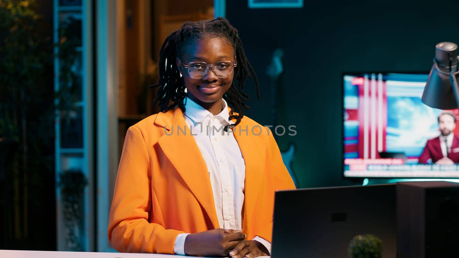 Portrait of university student sitting at her home desk using laptop to do school tasks. Young woman exploring career pathways and networking opportunities through professional platforms. Camera A.