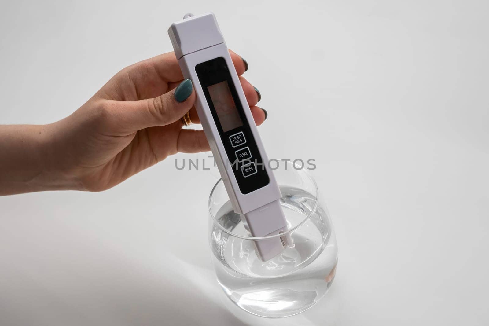 Woman uses a digital conductivity meter to check the purity of water.