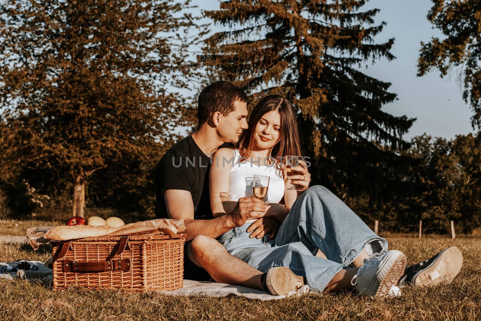 Young couple having a picnic in the park. by Nataliya