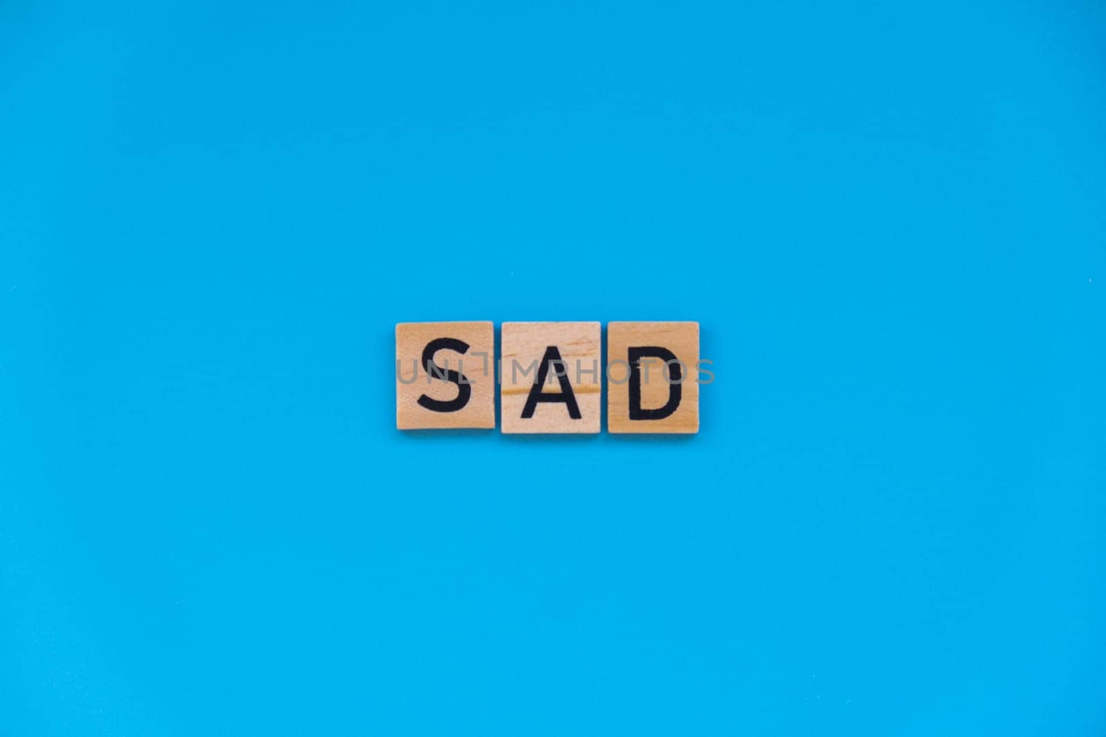 Seasonal affective disorder - text of wooden blocks on blue bright background. Concept of depression mood stress and anxiety. SAD wellbeing