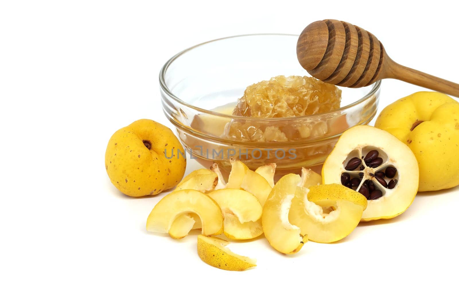 Glass with honey surrounded by vibrant quince fruits, both sliced and whole isolated on white background, full depth of field