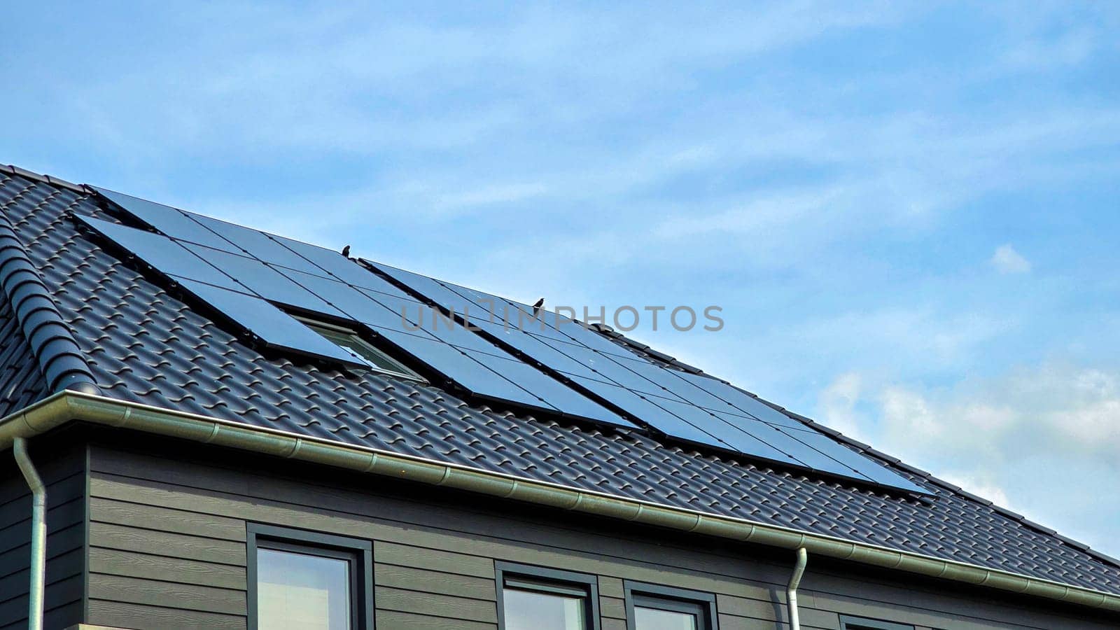Newly built houses with black solar panels on the roof, Close up of new family home with black solar panels. Zonnepanelen, Zonne energie, Translation: Solar panel, Sun Energy