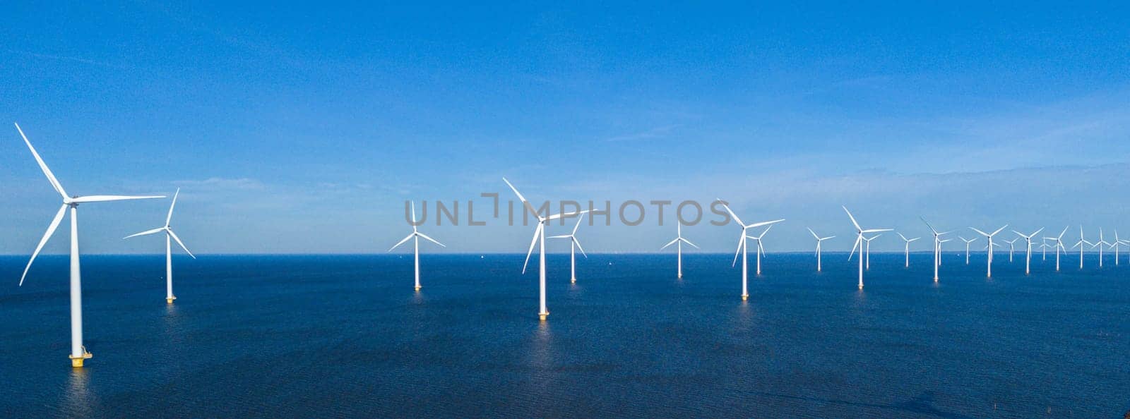 offshore windmill park and a blue sky, windmill park in the ocean. Netherlands Europe. windmill turbines in the Noordoostpolder Flevoland