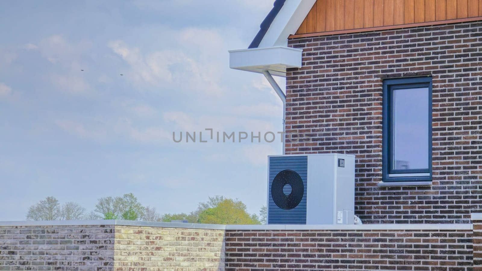 air source heat pump unit installed outdoors at a modern home with bricks in the Netherlands by fokkebok