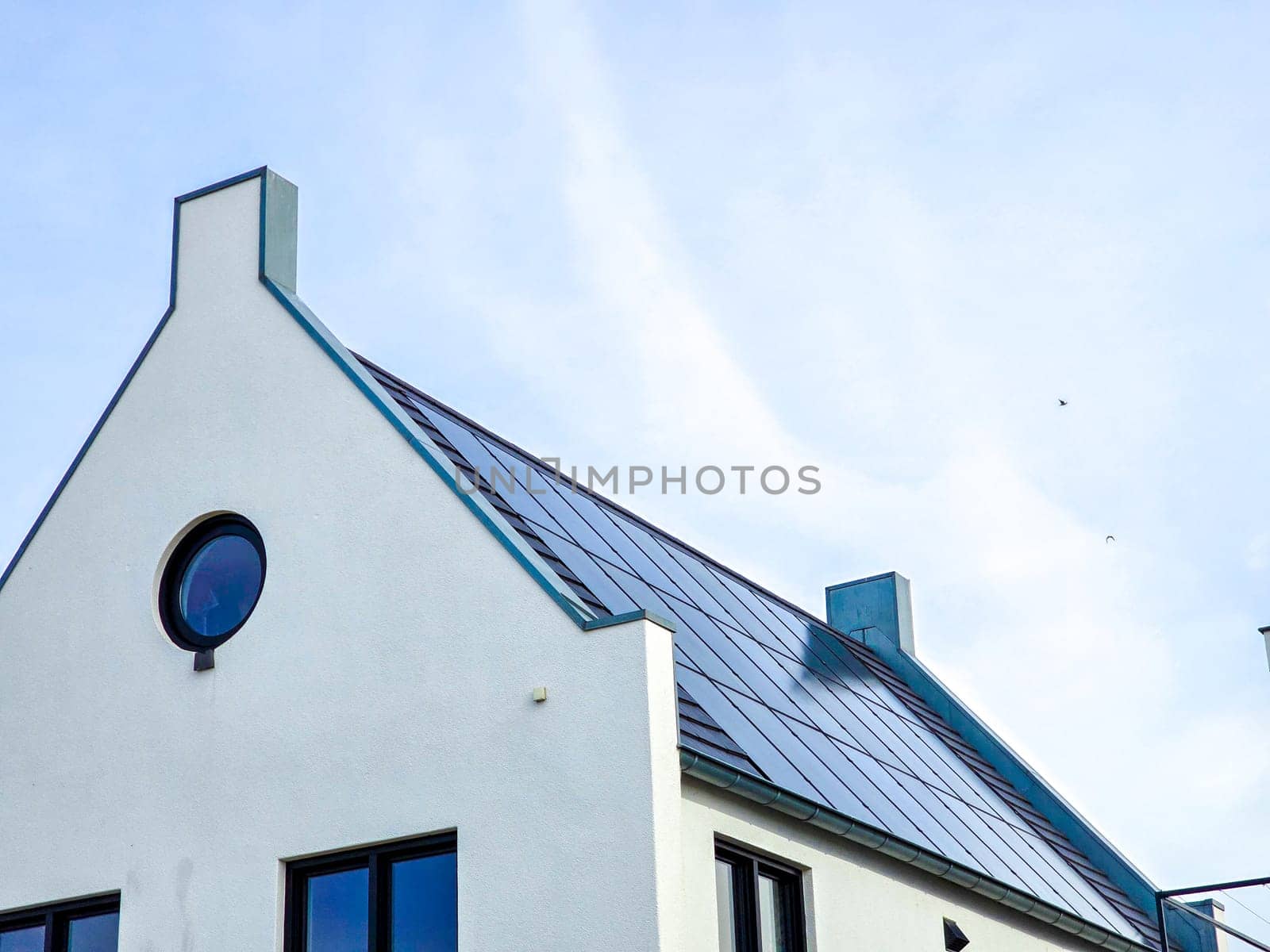 Newly build houses with solar panels attached on the roof against a sunny sky by fokkebok