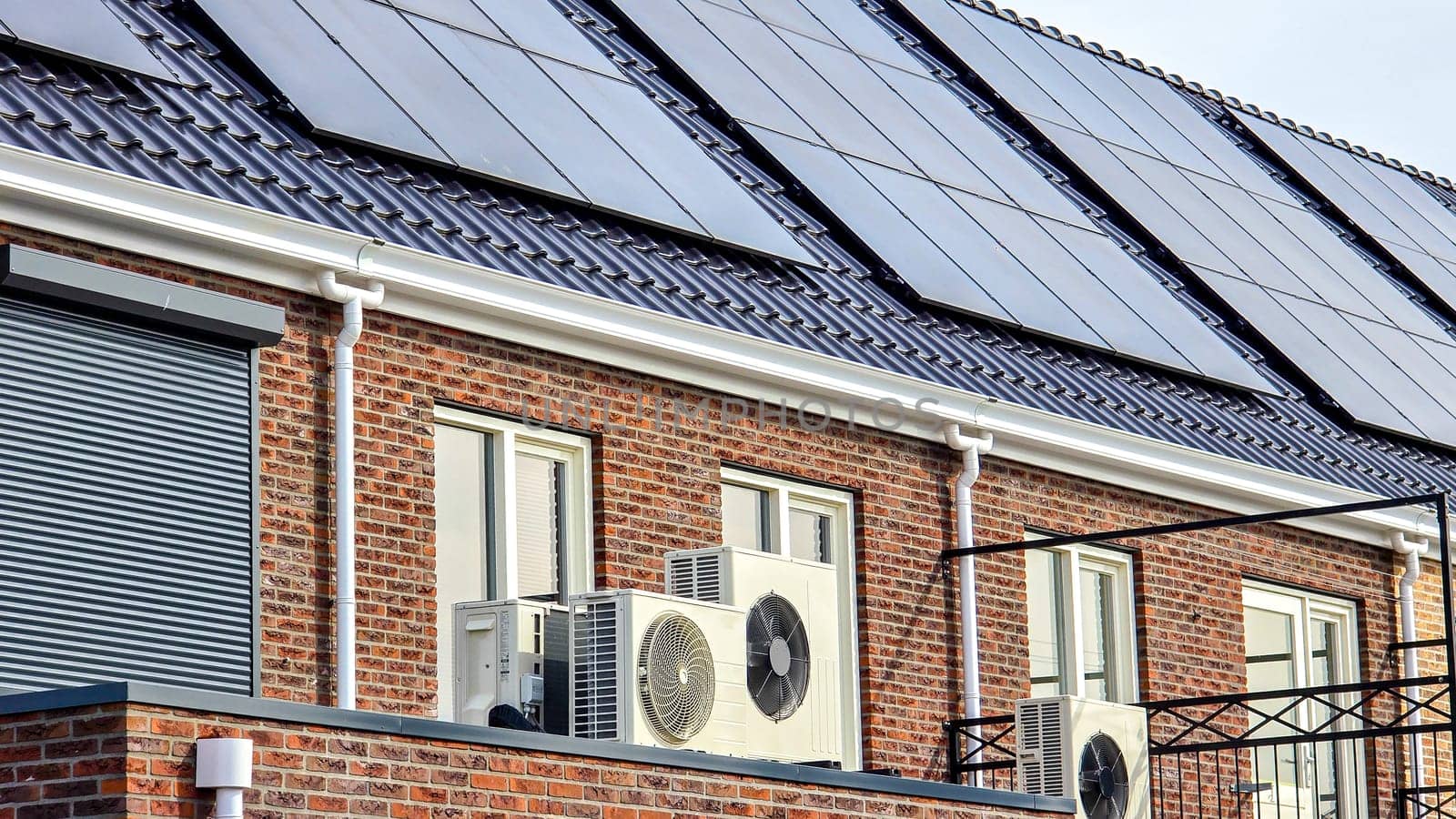 air source heat pump unit installed outdoors at a modern home with solar panels in the Netherlands by fokkebok