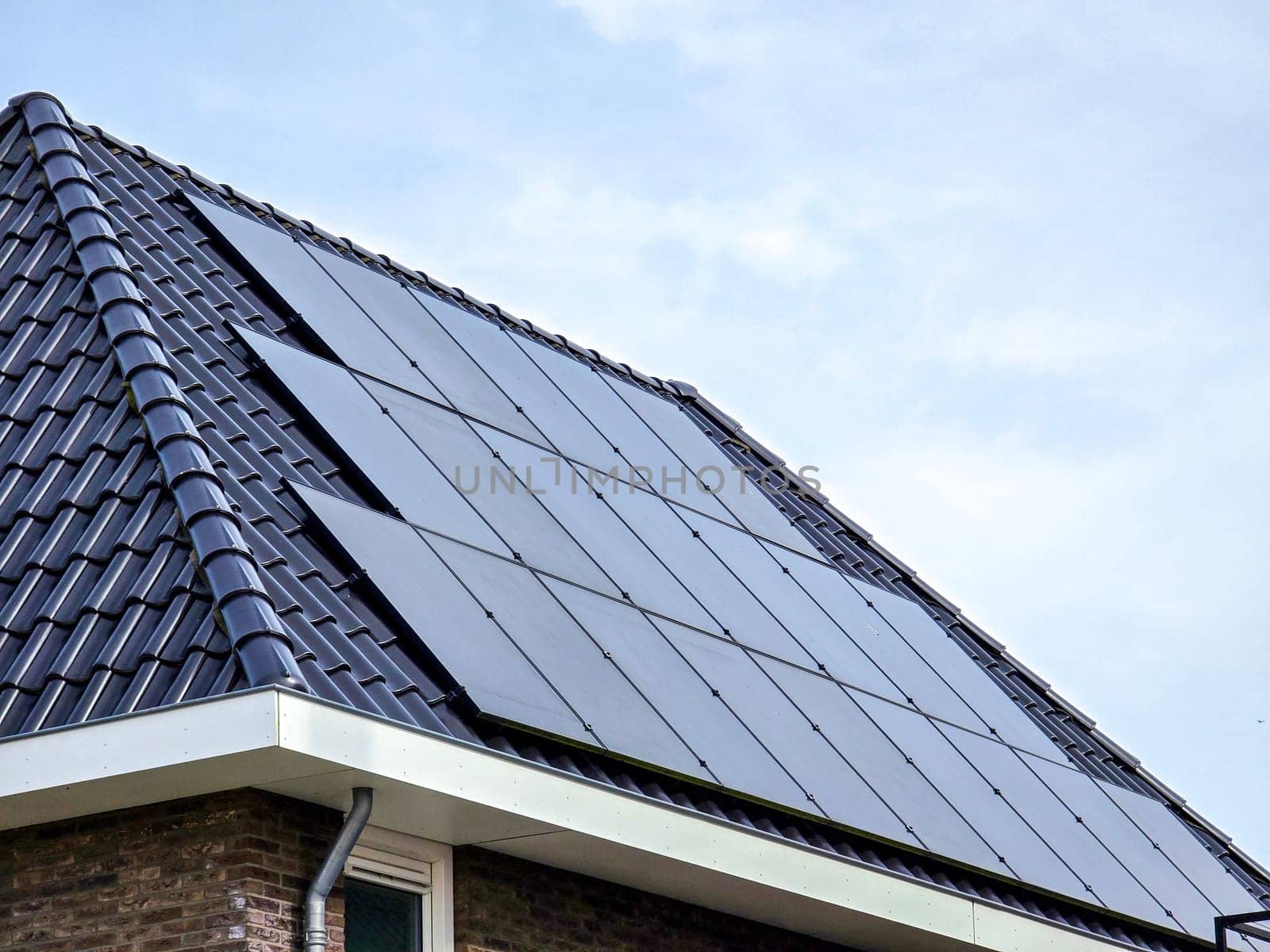 Newly built houses with black solar panels on the roof,Close up of new modern home with black solar panels. Zonnepanelen, Zonne energie, Translation: Solar panel, Sun Energy
