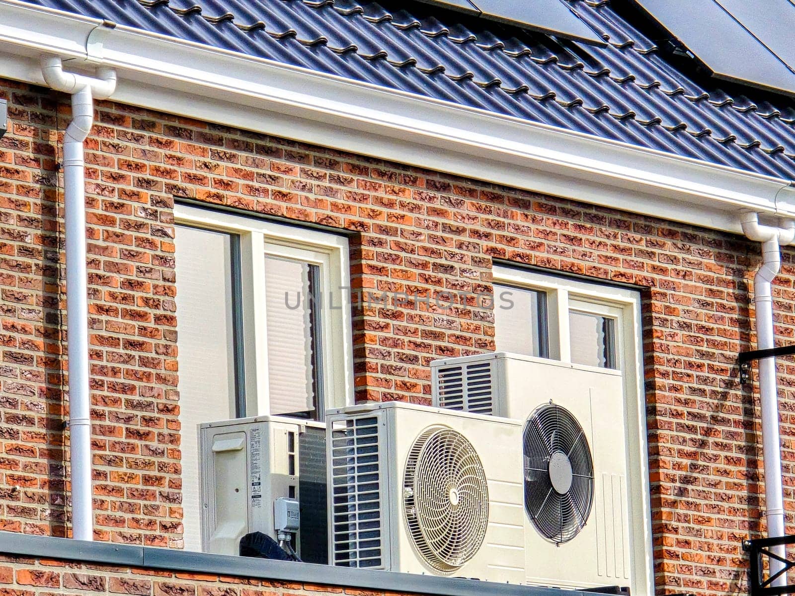 air source heat pump unit installed outdoors at a modern home with solar panels in the Netherlands by fokkebok