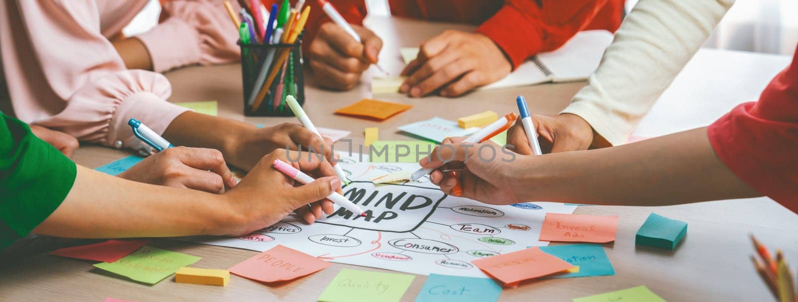 Creative business team brainstorming about marketing strategy and business plan by using mind mapping. Startup team work together to write down on paper. Focus on hand. Closeup. Variegated.