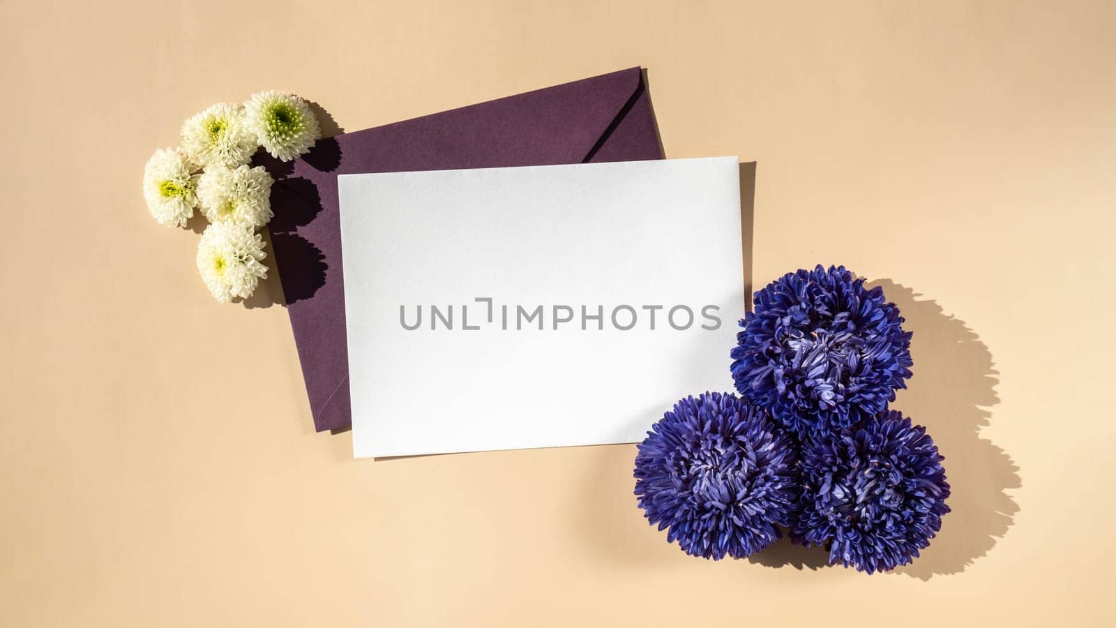 Composition with empty paper note and envelope beautiful spring violet and white flowers on beige background. Mockup card invitation greeting card postcard copy space template by anna_stasiia