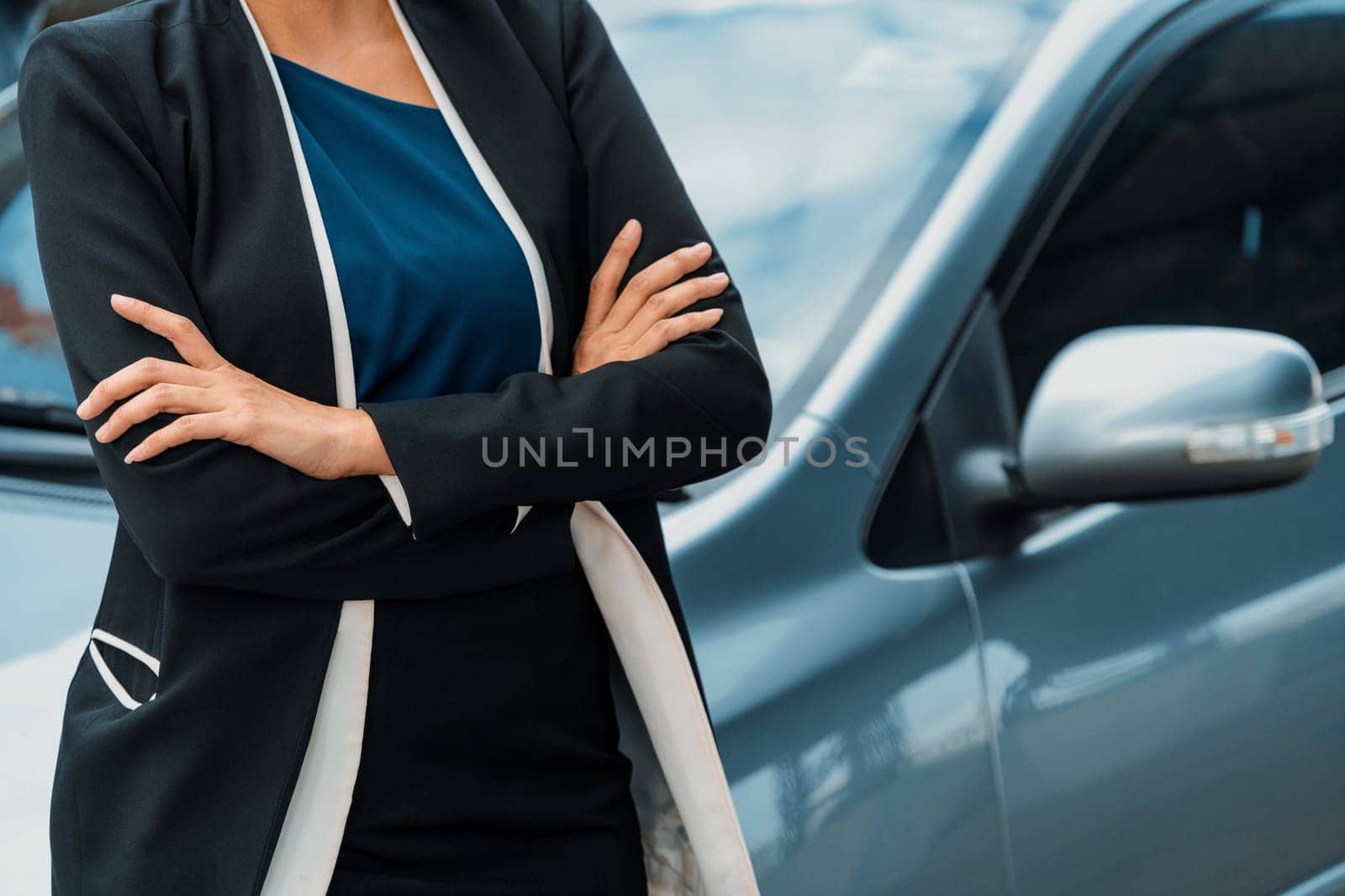 Confident professional business woman standing beside the car. Concept of car rental business and sales occupation. uds