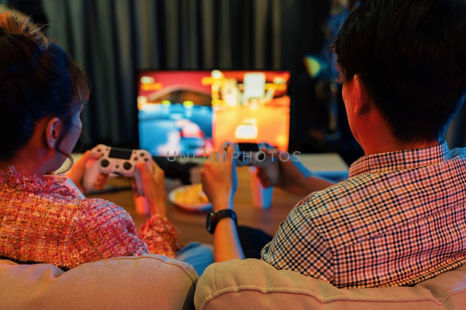 Couple gamer with joysticks playing fighting video game together tv. Infobahn. by biancoblue