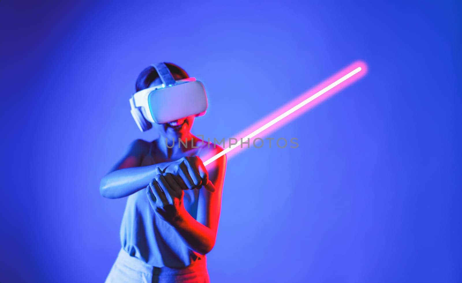 Woman in metaverse playing sword-fighting game using laser saber. Hallucination. by biancoblue