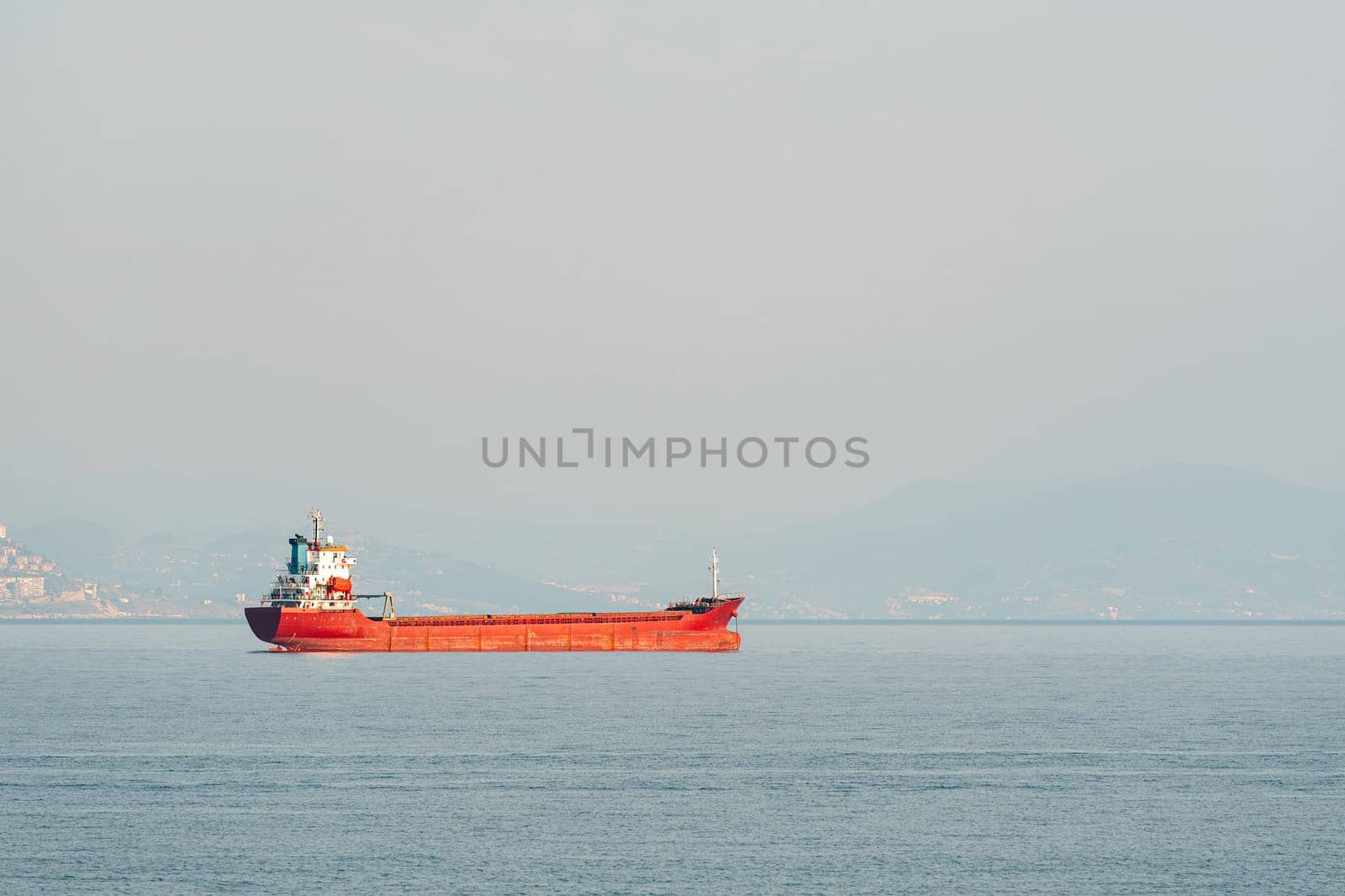 Orange general cargo ship anchored off the coast of Alanya, Antalya