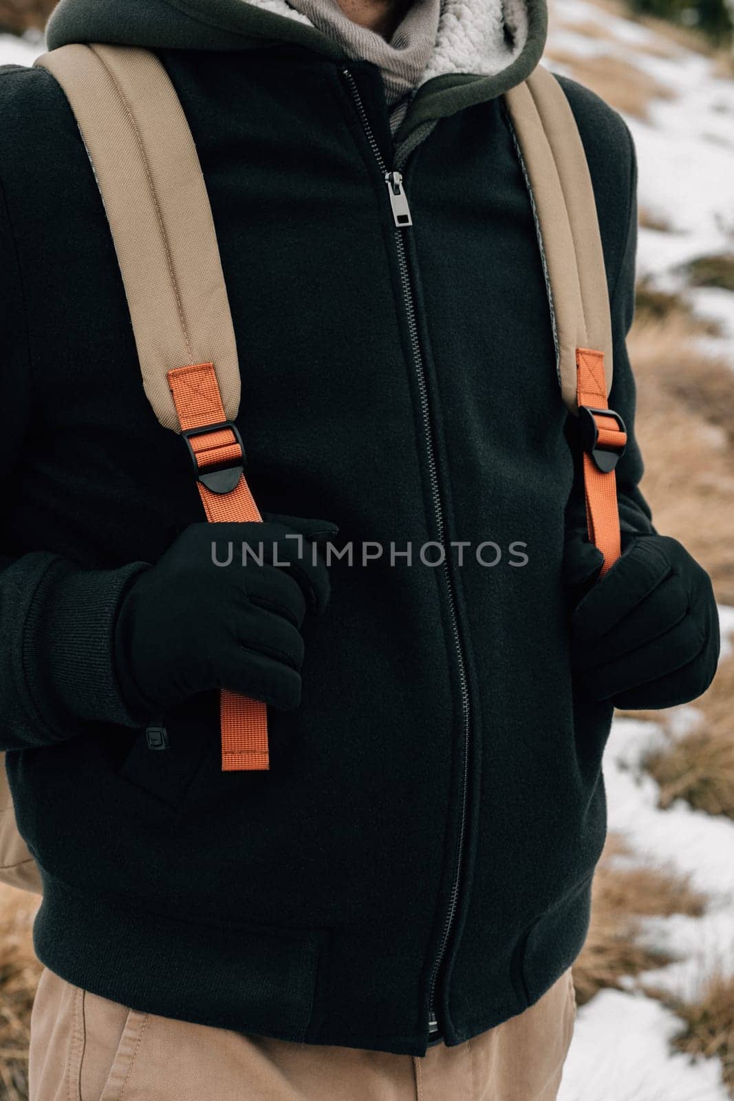Close-up of a person dressed in winter fashion with a focus on the fleece jacket and backpack straps